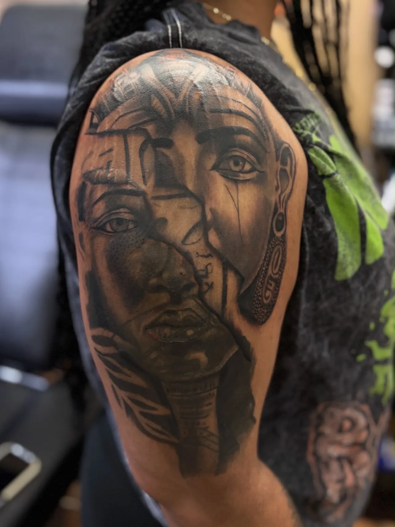 Nefertiti portrait upper-arm tattoo in black and grey